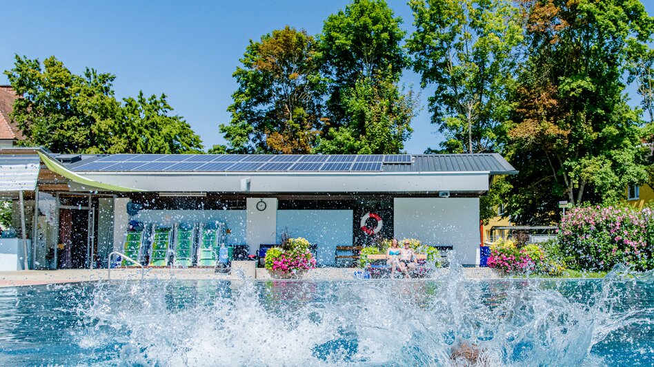 Wasser im Freibad spritzt durch Sprung ins Wasser