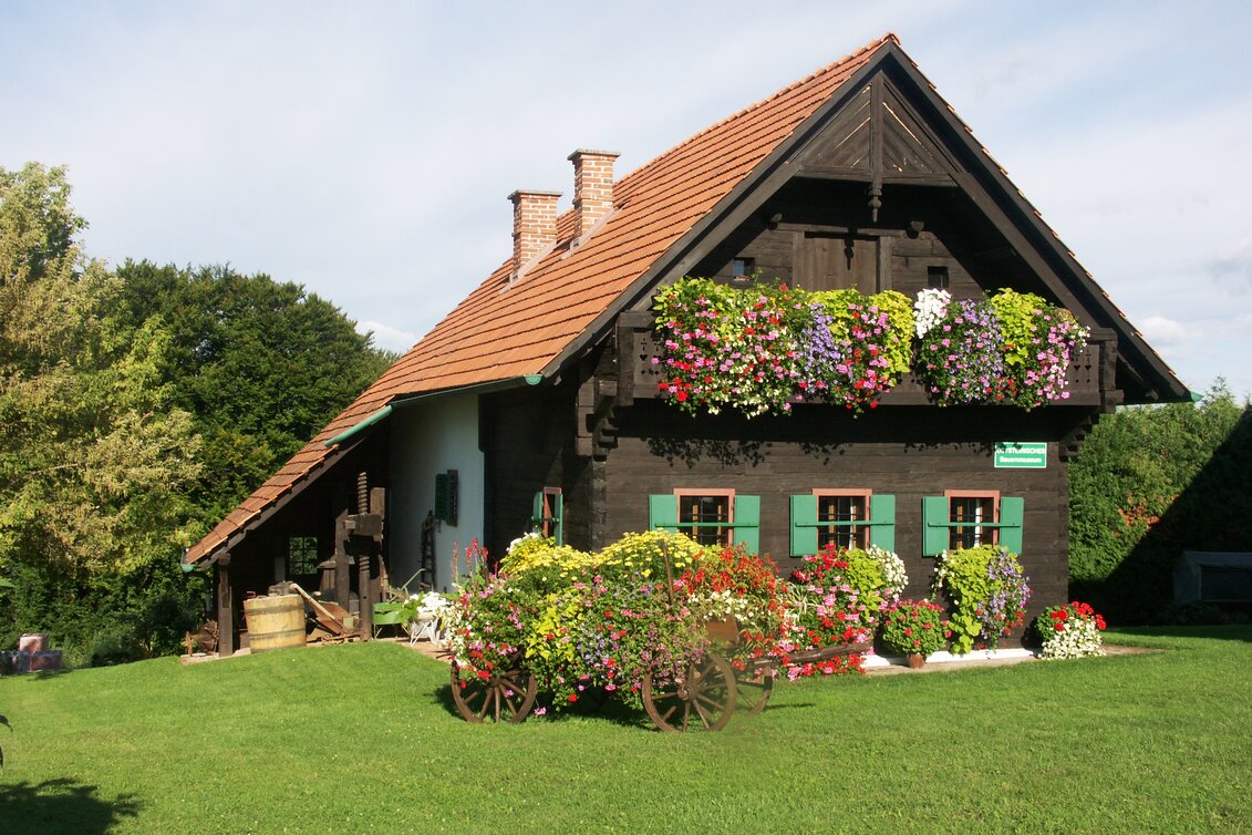 Heimatmuseum in Buch-St. Magdalena mit traditionellem Bauernhaus und farbenprächtigem Blumenschmuck im Thermen- & Vulkanland Steiermark. | © Gemeinde Buch St. Magdalena