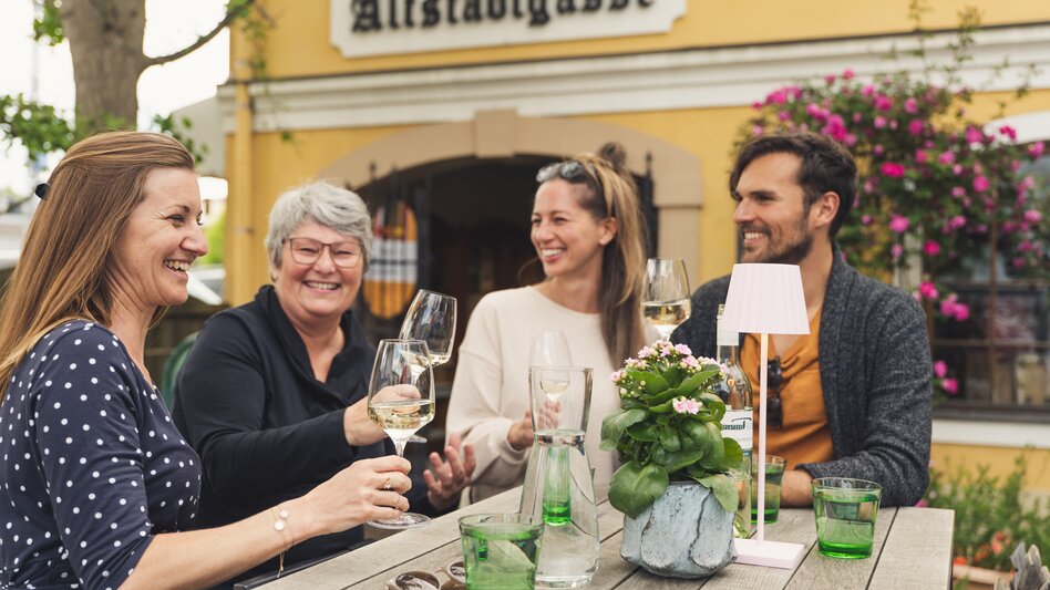 Freunde stoßen in Sissi´s Weinbar mit Weingläsern an