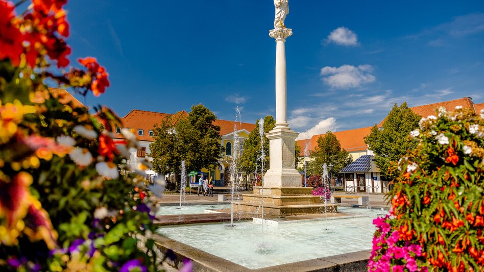 Marienbrunnen am Fürstenfelder Hauptplatz mit Sommerblumen