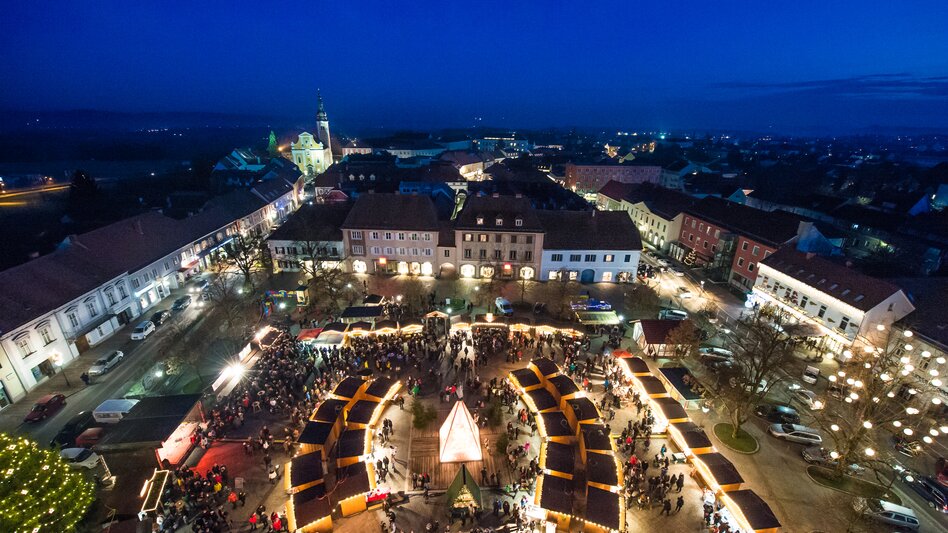 Blick von oben auf den Weihnachtsmarkt am Hauptplatz in Fürstenfeld bei Abendstimmung