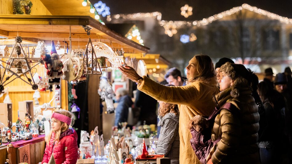 Frau sieht sich das Kunsthandwerk am Weihnachtsmarkt Fürstenfeld an