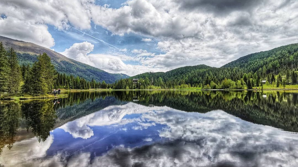 See mit Wolkenspiegelung im Wasser