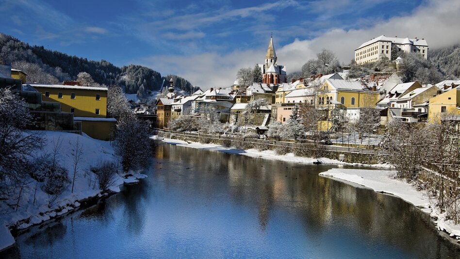 Blick auf Mur und das winterliche Murau mit verschneiten Gebäuden