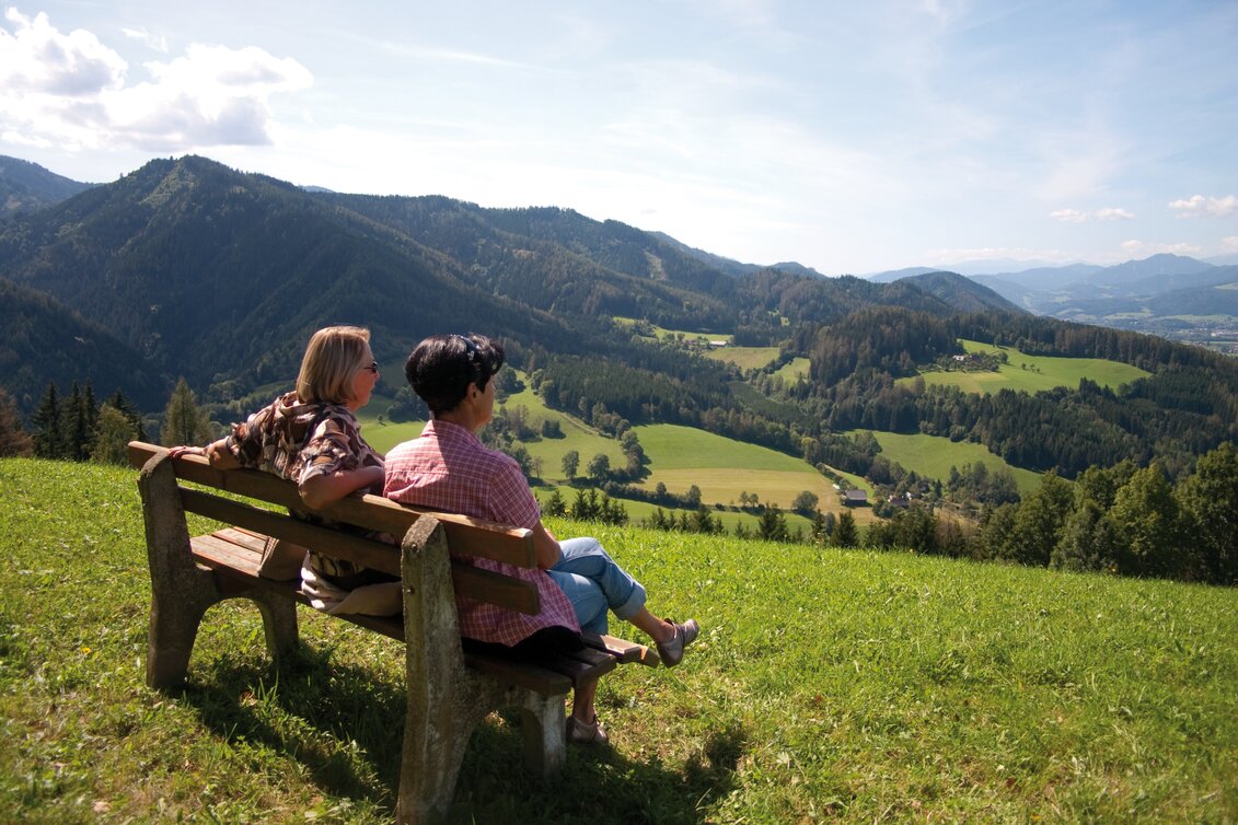 Ein Mann und eine Frau sitzen auf einer Bank und schauen in die Ferne