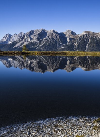 Speicherteich auf der Planai spiegelt den Dachstein