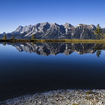 Speicherteich auf der Planai spiegelt den Dachstein | © STG | photo-austria.at